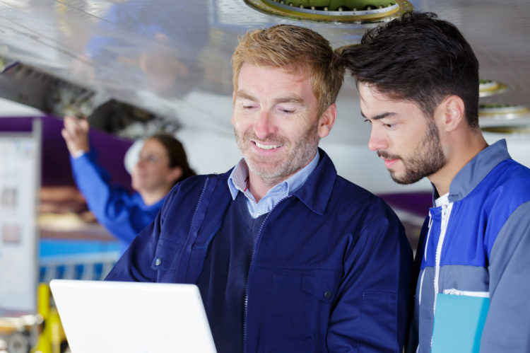 two mechanics working on a small aircraft