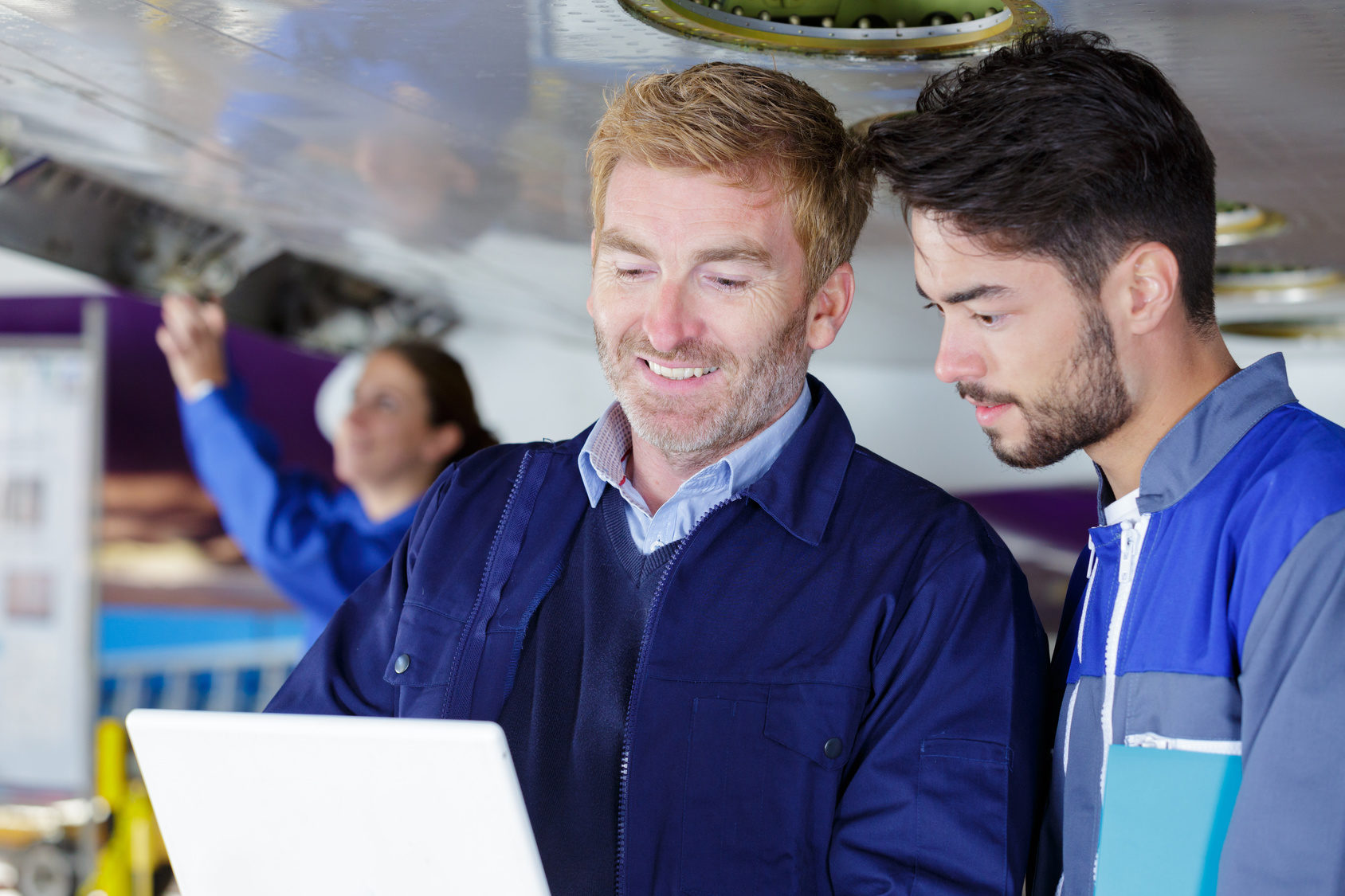 two mechanics working on a small aircraft