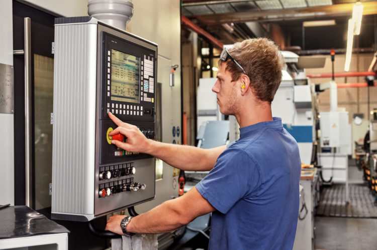 Skilled worker controlling a CNC machine xxl: bartussek.xmstore