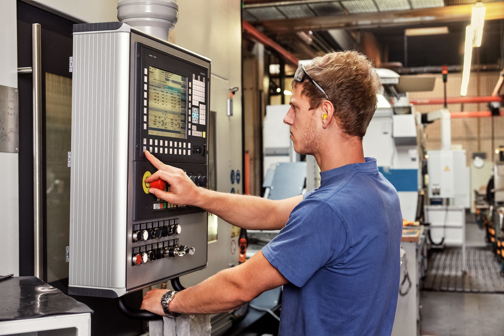 Skilled worker controlling a CNC machine xxl: bartussek.xmstore