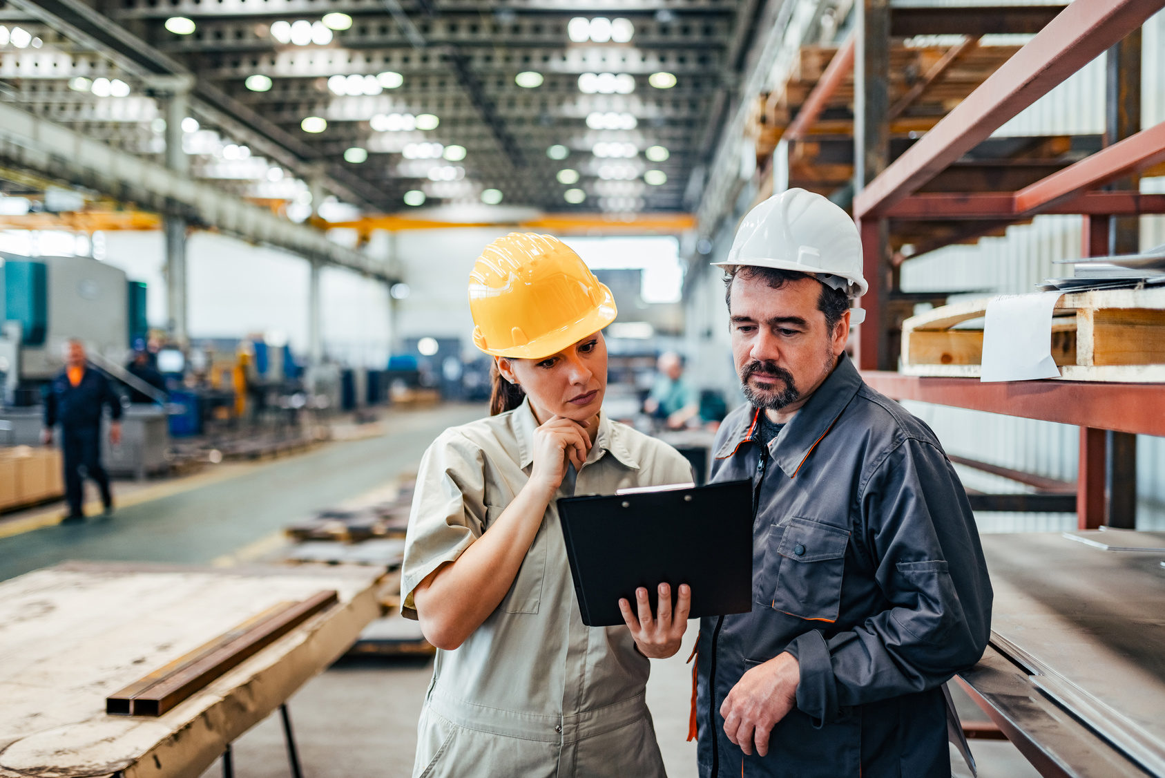 Female supervisor and mature engineer looking at document and pl